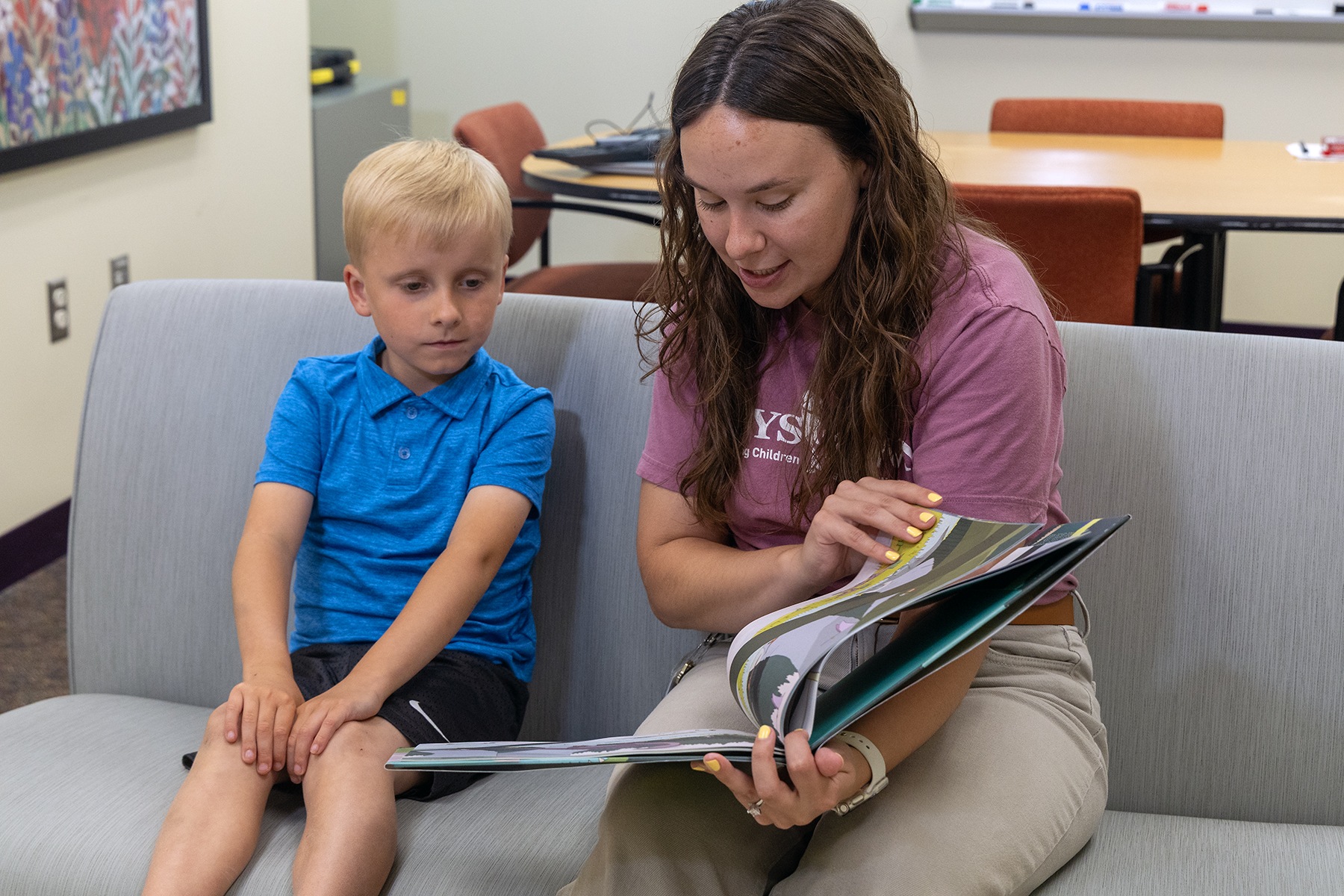 young boy reading with research