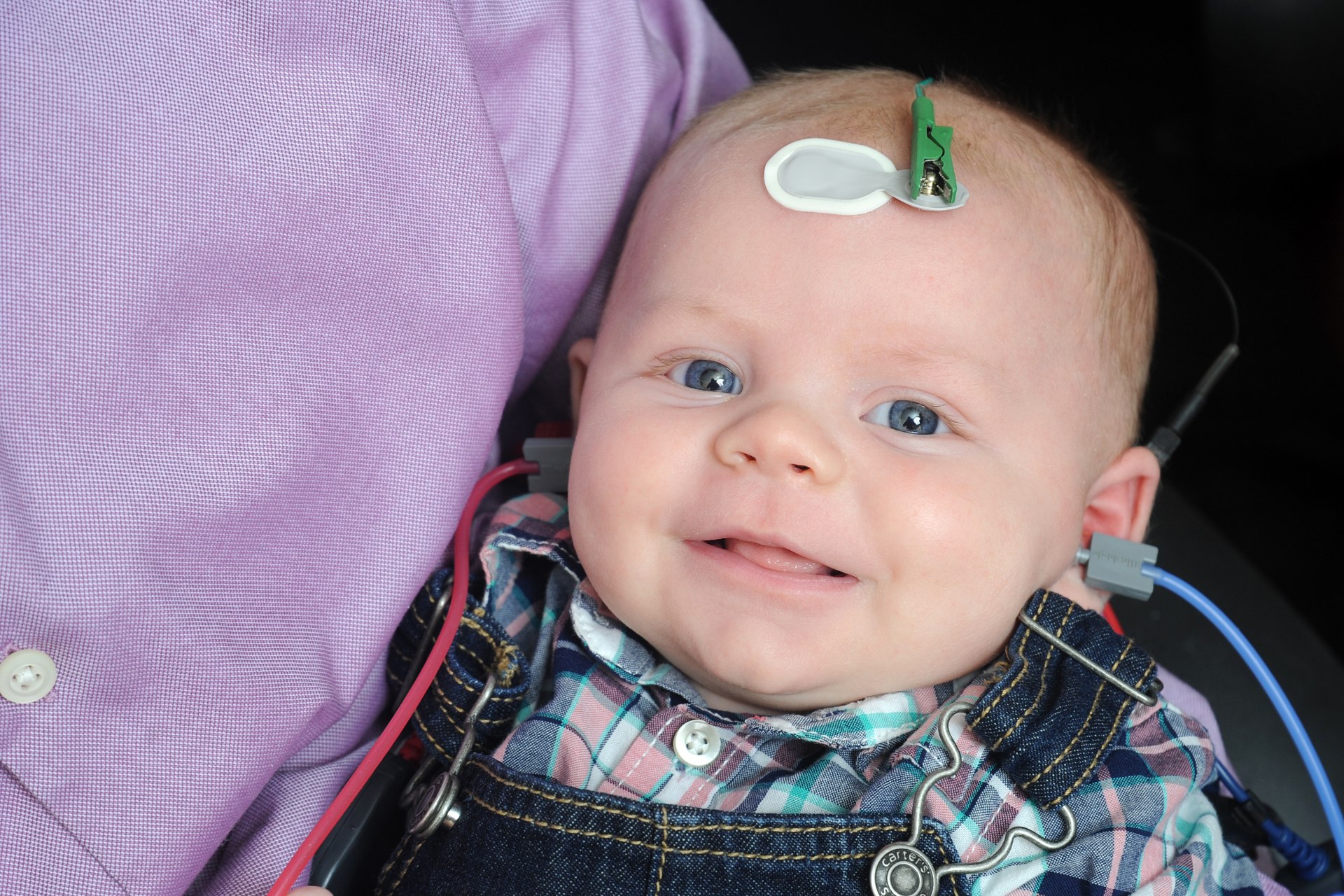 baby being help recieving hearing test