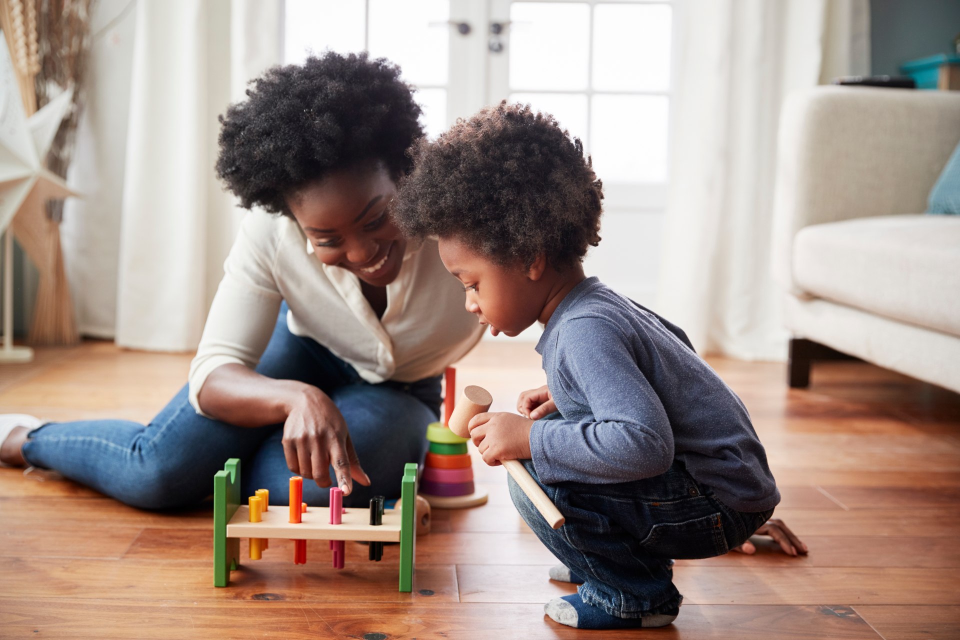 mother and boy playing with toy on the floor