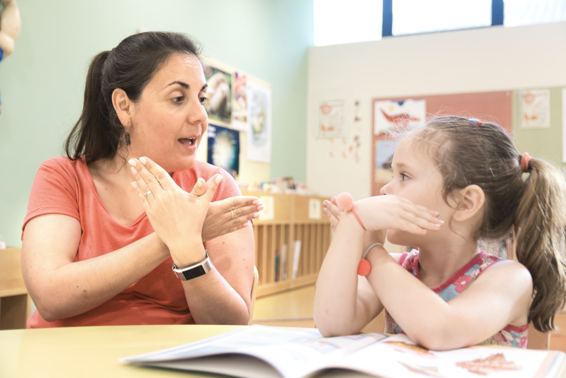 child and adult using sign language