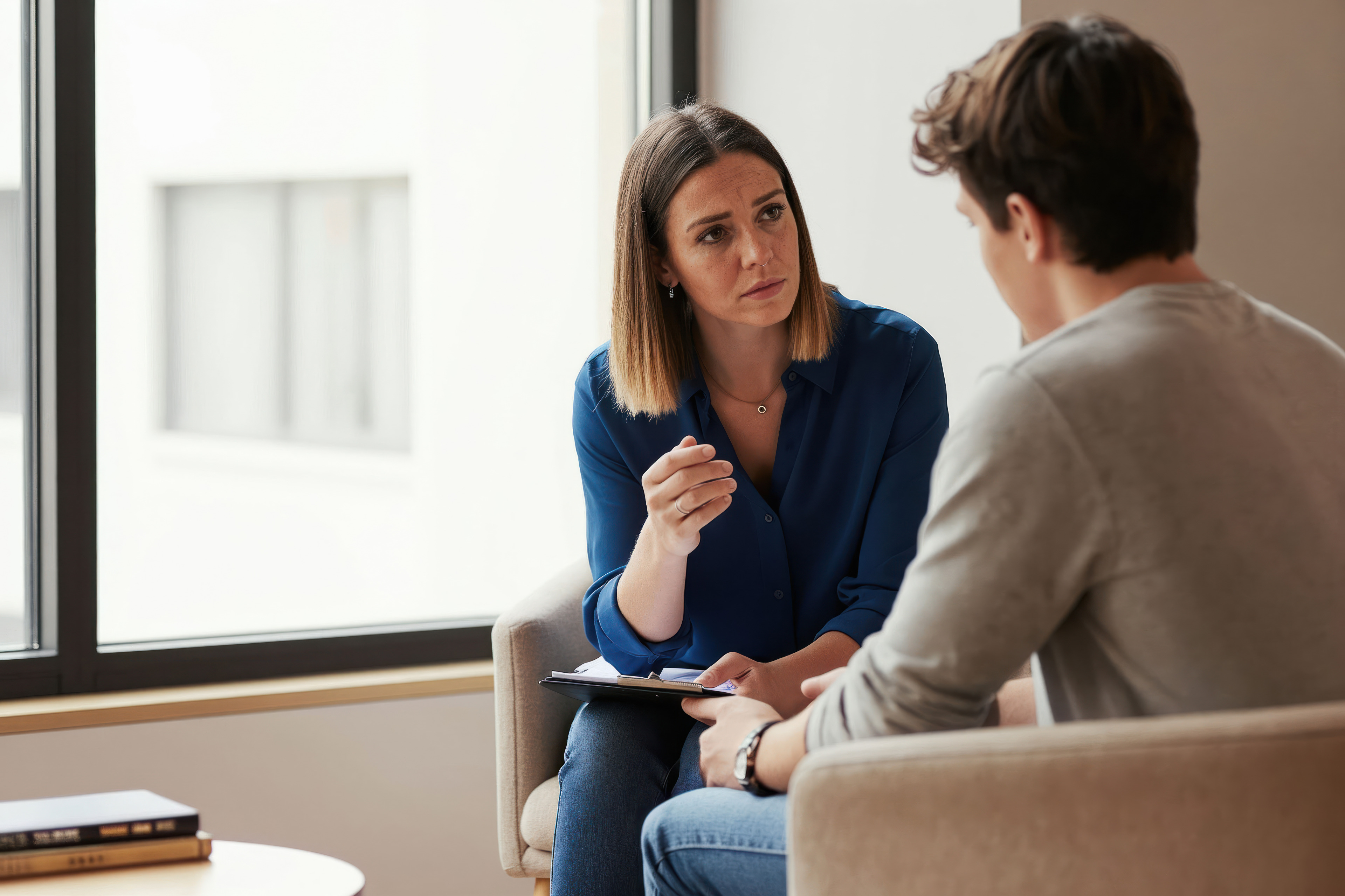 Therapist talks to teenage boy in office