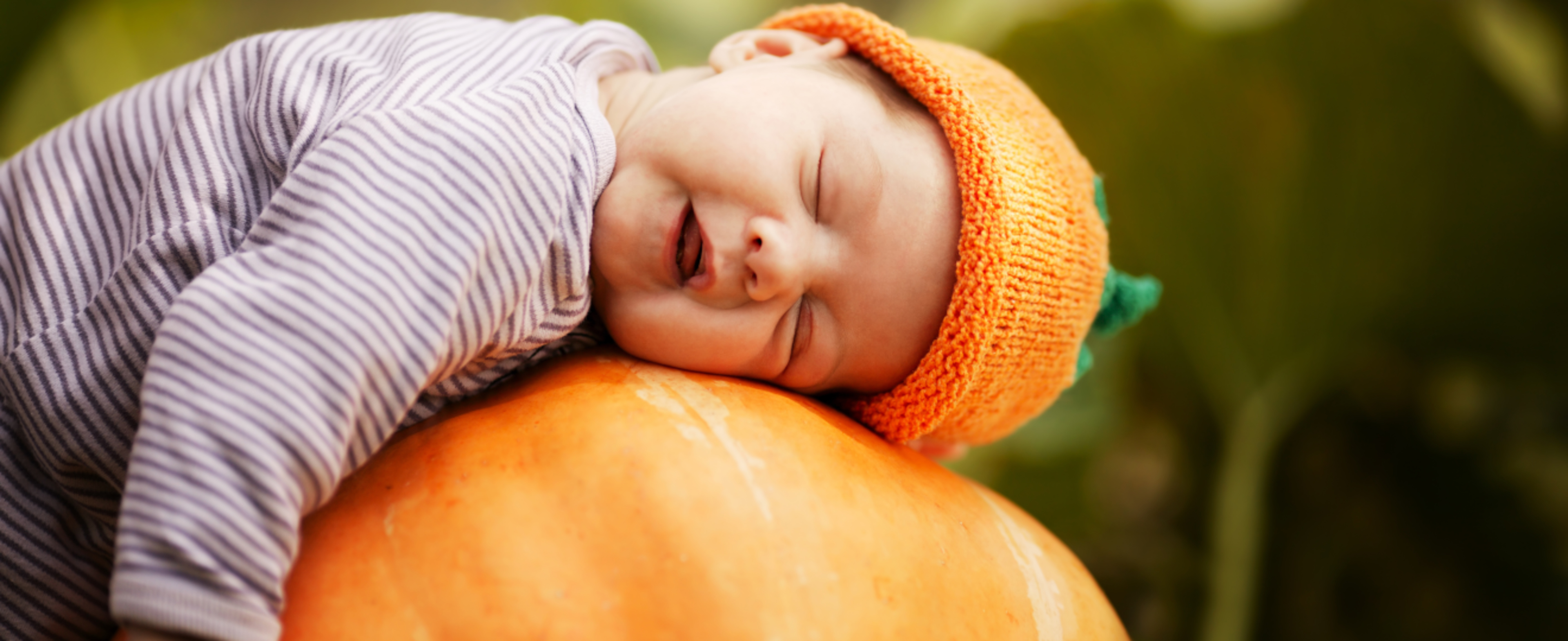 Baby sleeping on a pumpkin