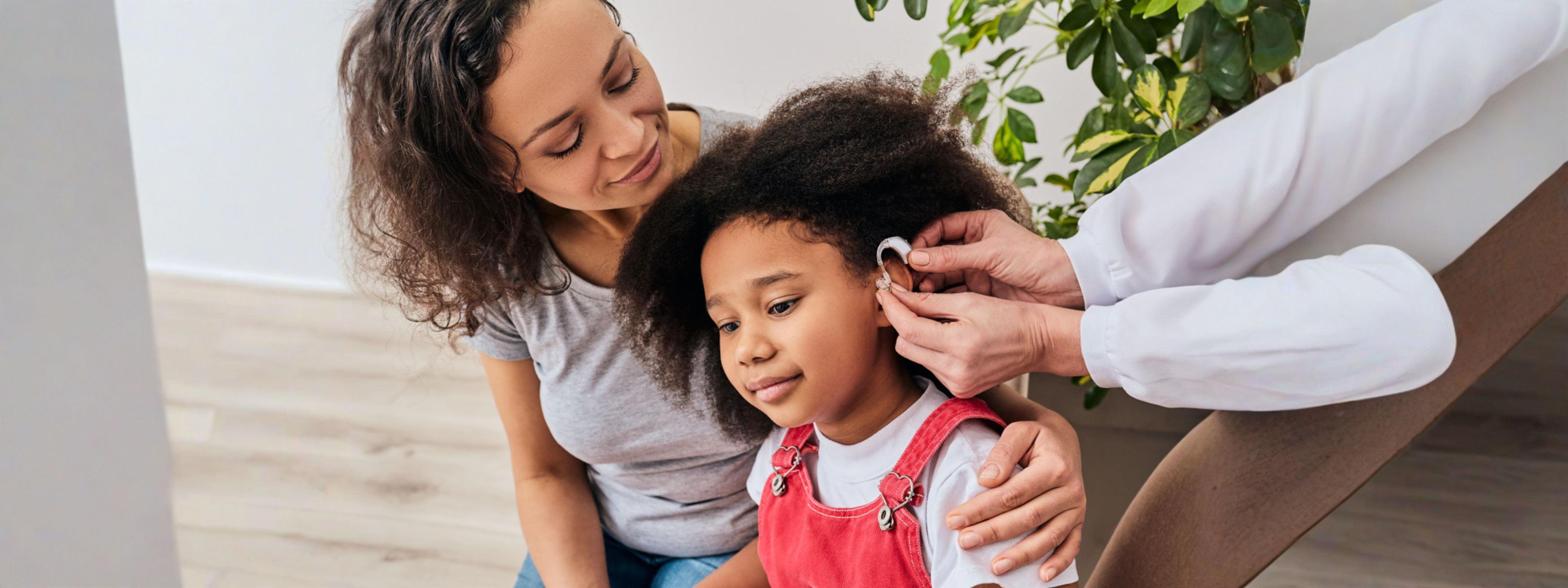 Mother with daughter getting hearing device