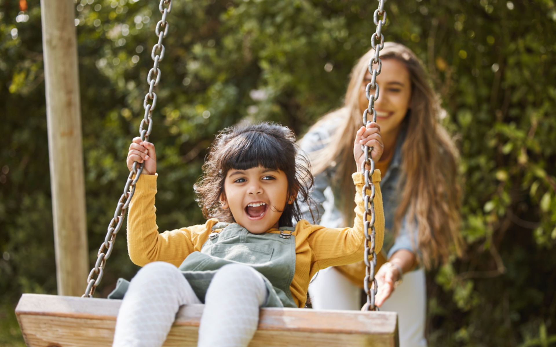 parent-pushing-child-on-the-swing