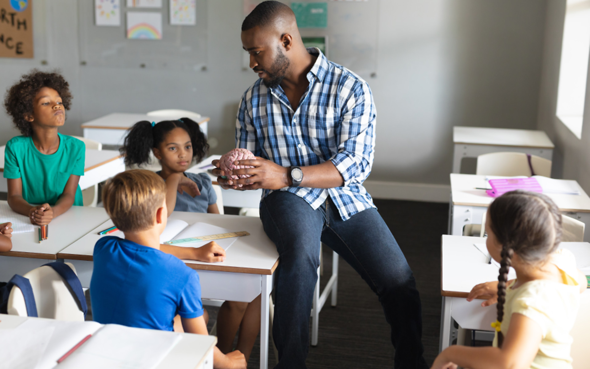 Students listening at teacher in classroom