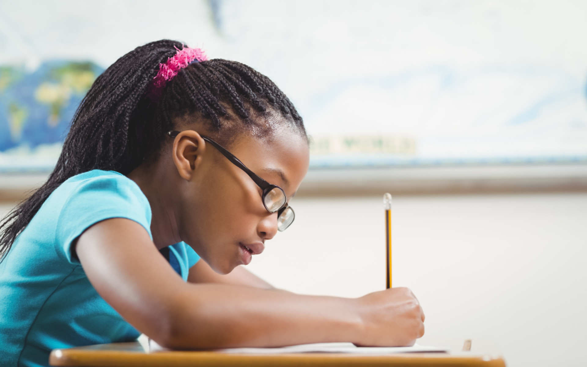 young-girl-writing-school-desk